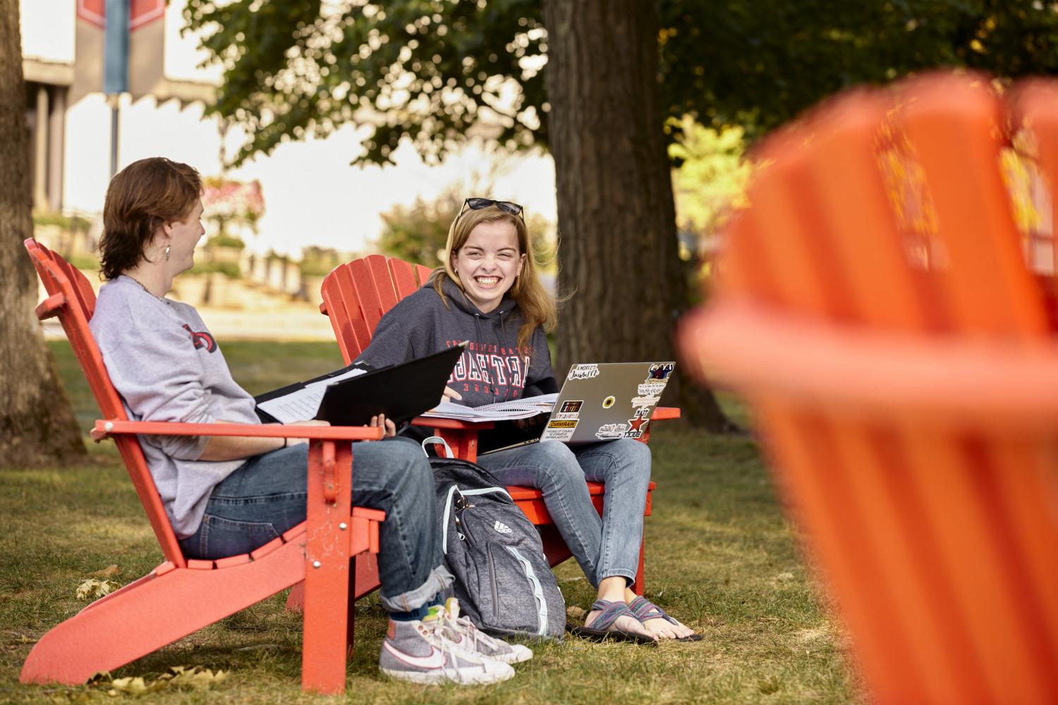 Students hang out in the red Adirondack chairs between classes.